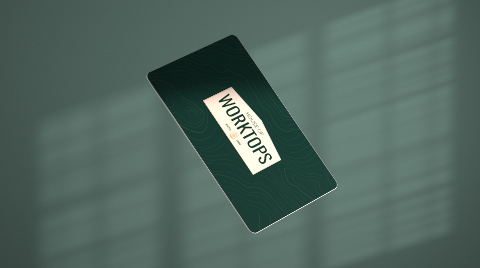 A green business card resting on a wooden table surface.